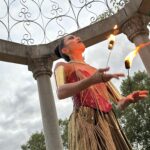 Fire dancer performing in Chicago during a luxury nightlife event with dramatic flames and audience focus